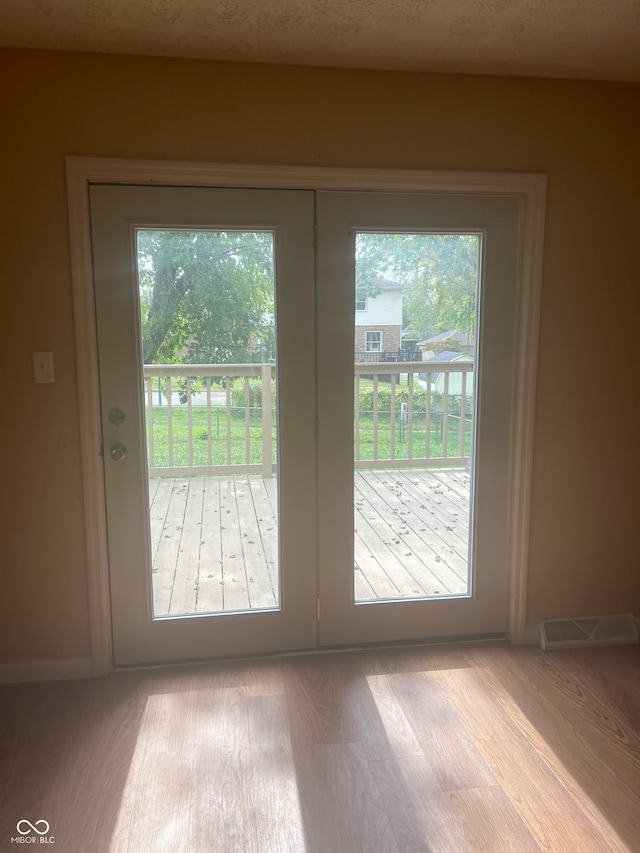 entryway featuring french doors, light wood-type flooring, and a wealth of natural light