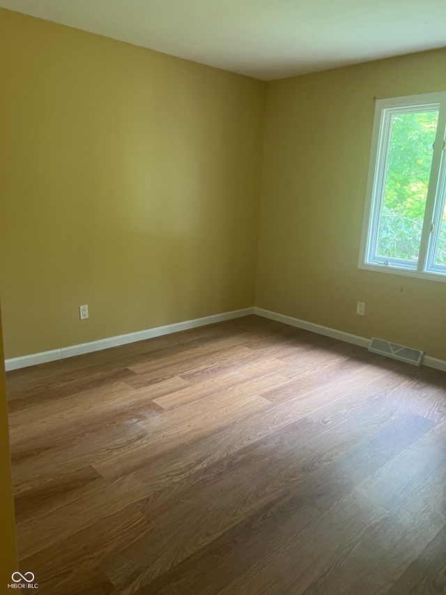 spare room with wood-type flooring