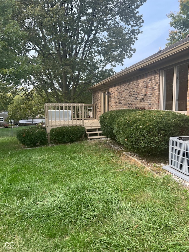 view of yard featuring central AC and a deck