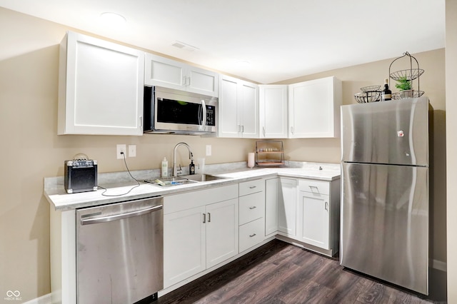 kitchen featuring dark wood-type flooring, appliances with stainless steel finishes, sink, and white cabinetry