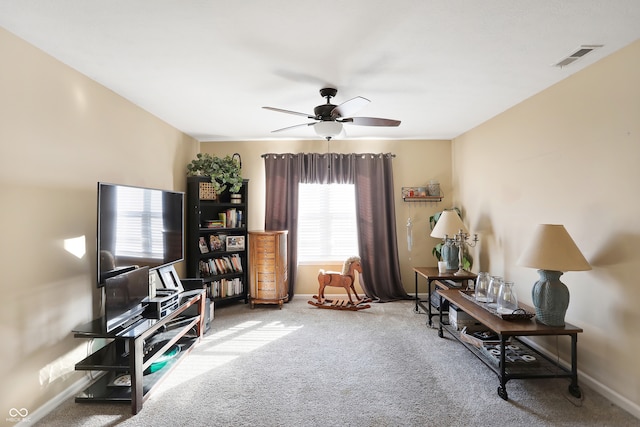 living area featuring carpet flooring, plenty of natural light, and ceiling fan