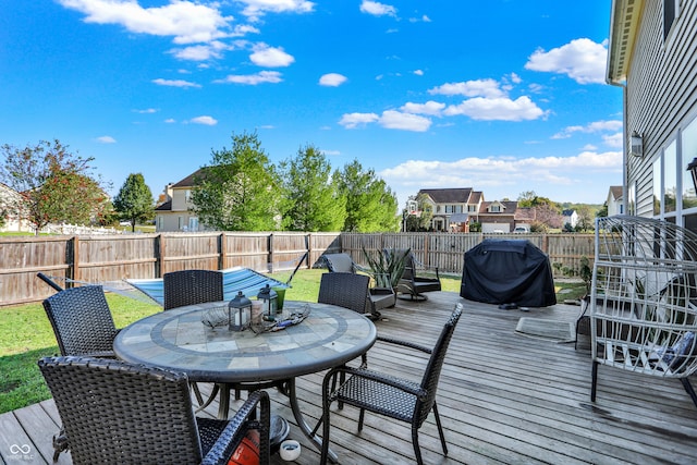 wooden deck with area for grilling and a yard