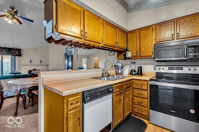 kitchen featuring kitchen peninsula, white dishwasher, sink, stainless steel range with electric cooktop, and ceiling fan