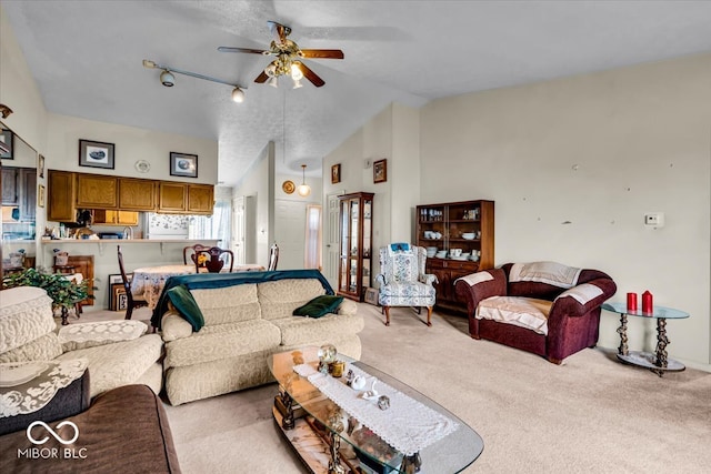 carpeted living room with ceiling fan and high vaulted ceiling