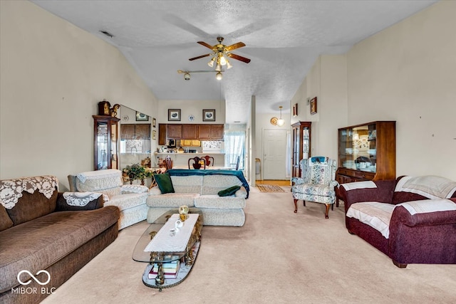 living room with light carpet, a textured ceiling, high vaulted ceiling, and ceiling fan