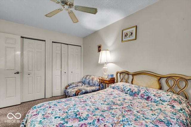 carpeted bedroom with two closets and ceiling fan