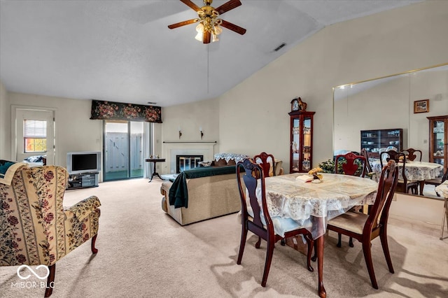 carpeted dining area with lofted ceiling and ceiling fan