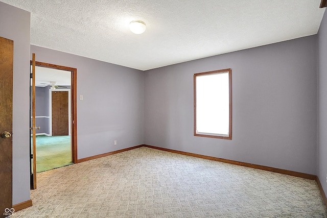 carpeted empty room featuring a textured ceiling