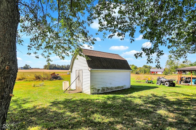 view of outdoor structure with a rural view and a lawn