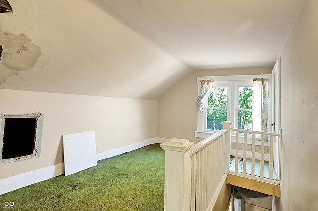 bonus room with vaulted ceiling and carpet