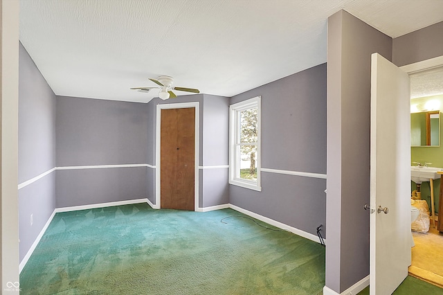 unfurnished room featuring ceiling fan, a textured ceiling, and carpet flooring