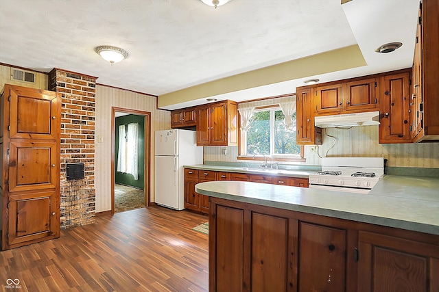 kitchen with dark wood-type flooring, white appliances, brick wall, and sink