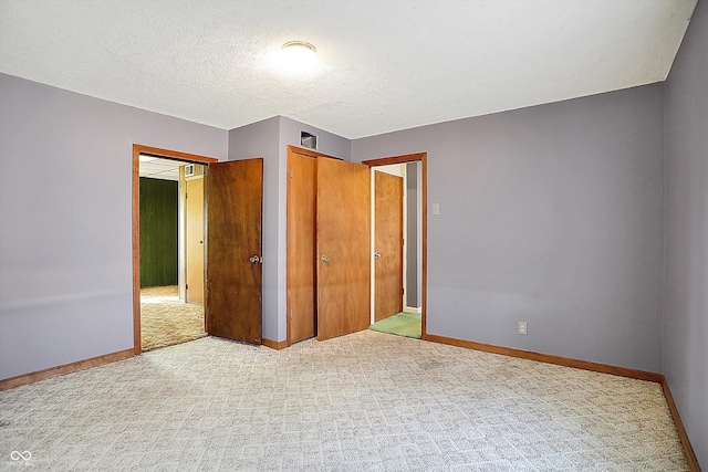 unfurnished bedroom with a textured ceiling and light carpet