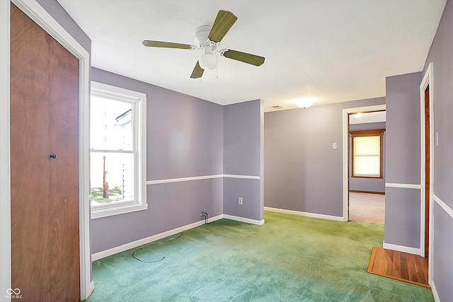 unfurnished room with ceiling fan and carpet