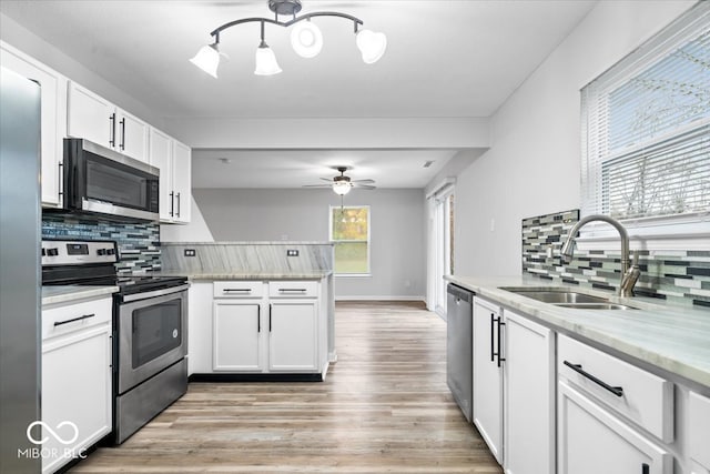 kitchen featuring sink, white cabinets, stainless steel appliances, and a healthy amount of sunlight