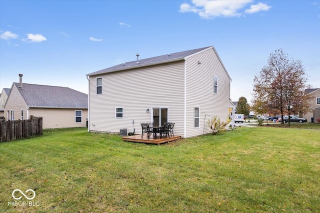 rear view of house featuring a wooden deck, cooling unit, and a yard