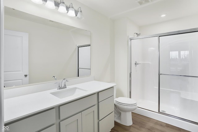 bathroom featuring toilet, hardwood / wood-style floors, vanity, and walk in shower