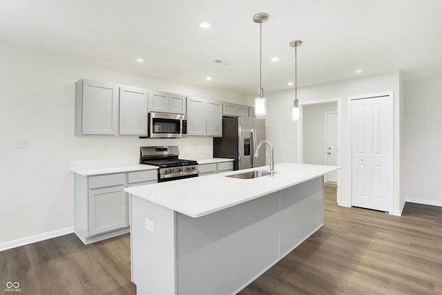 kitchen with stainless steel appliances, a kitchen island with sink, hardwood / wood-style flooring, and sink