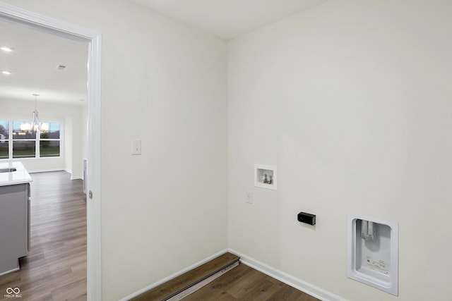 clothes washing area featuring wood-type flooring, an inviting chandelier, and hookup for a washing machine