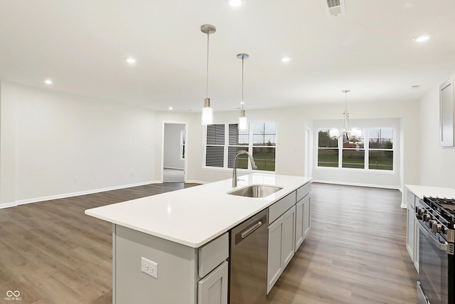 kitchen with appliances with stainless steel finishes, sink, decorative light fixtures, hardwood / wood-style flooring, and gray cabinets