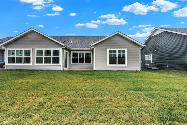 back of property with a yard and central AC unit