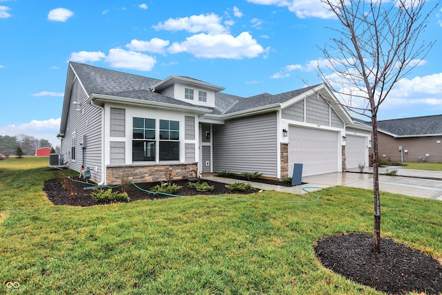 view of front of property with central AC unit, a garage, and a front lawn