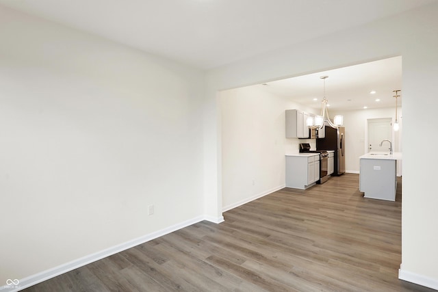 unfurnished living room with light hardwood / wood-style floors and sink