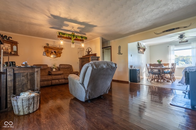 living room with ornamental molding, ceiling fan, dark hardwood / wood-style floors, and a textured ceiling