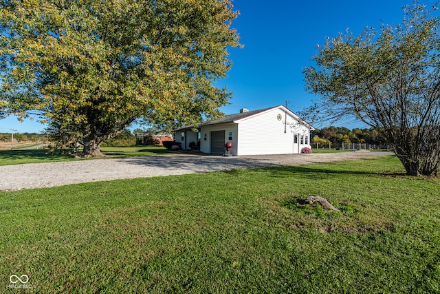 view of side of home featuring a garage and a yard