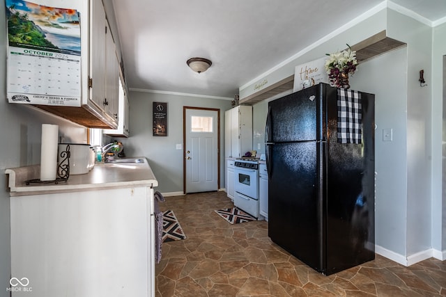 kitchen featuring black fridge, sink, ornamental molding, white cabinetry, and white gas stove