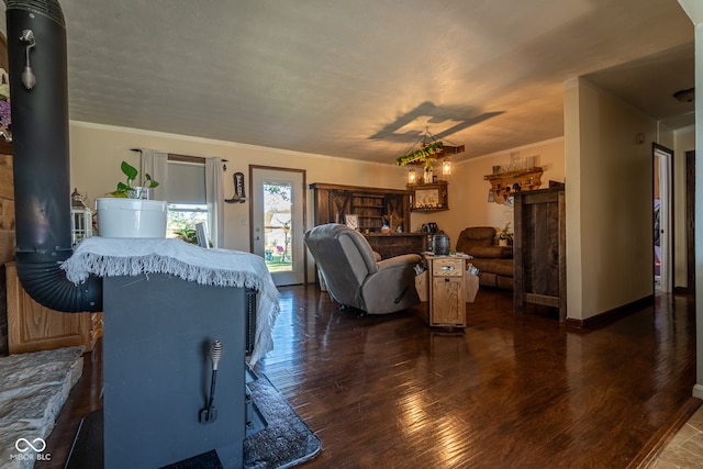 living room featuring dark hardwood / wood-style floors, a wood stove, and crown molding