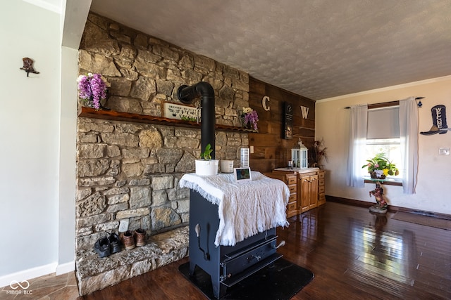 interior space featuring a wood stove, crown molding, hardwood / wood-style flooring, and a textured ceiling