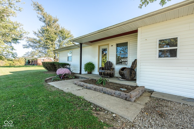 view of exterior entry featuring a yard