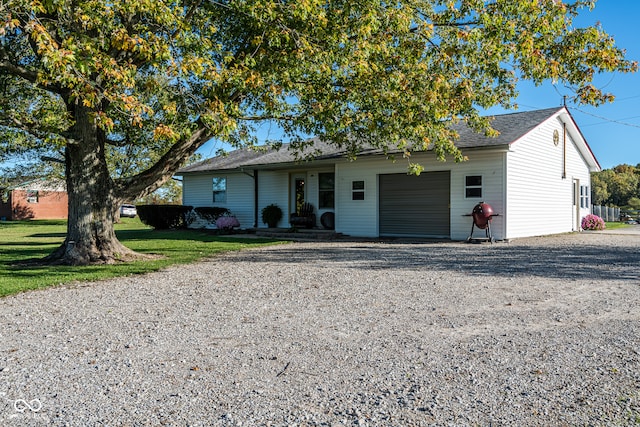 single story home featuring a garage and a front lawn