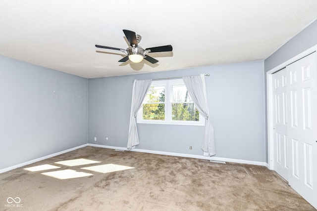 unfurnished bedroom with a closet, carpet floors, a textured ceiling, and ceiling fan