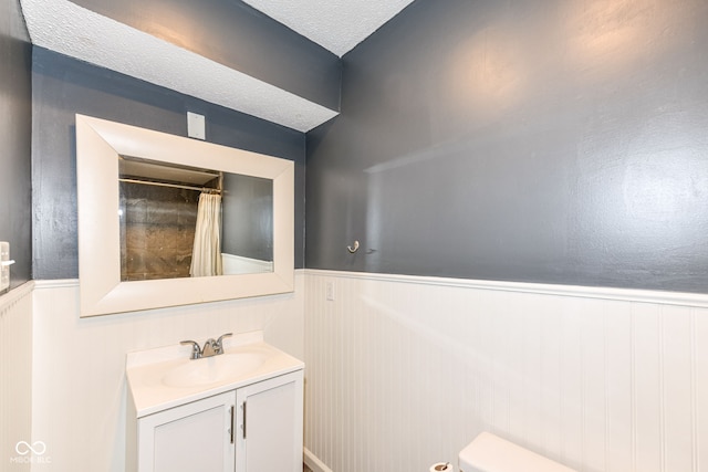 bathroom featuring vanity, toilet, and a textured ceiling