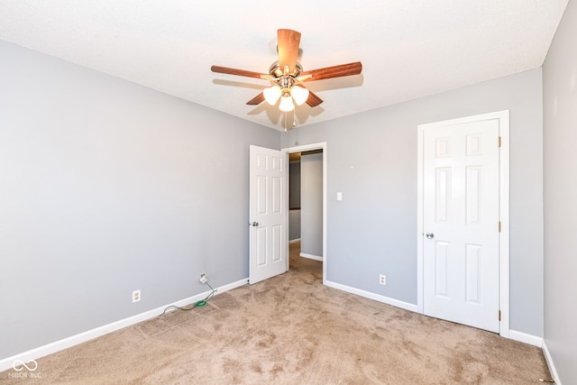 unfurnished bedroom featuring light carpet and ceiling fan