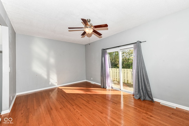 spare room with a textured ceiling, hardwood / wood-style flooring, and ceiling fan