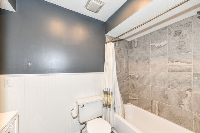 full bathroom featuring vanity, a textured ceiling, toilet, and shower / bathtub combination with curtain