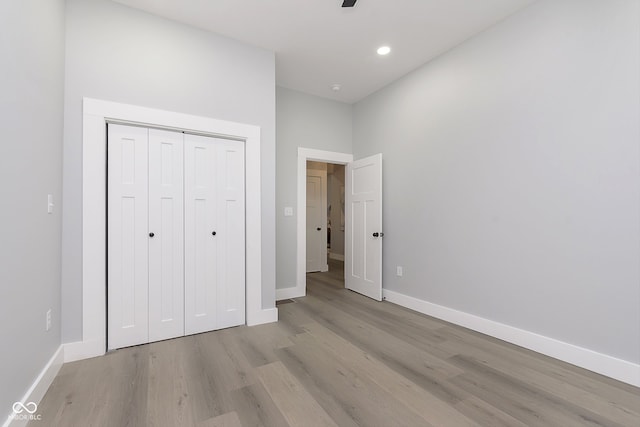 unfurnished bedroom with light hardwood / wood-style floors and a closet