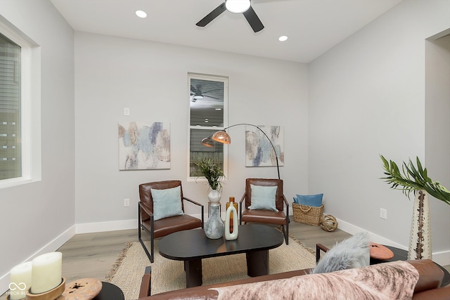 living area with light wood-type flooring and ceiling fan