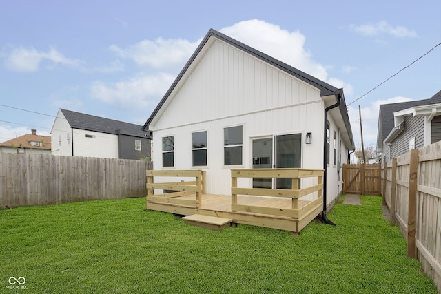 rear view of property featuring a yard and a deck