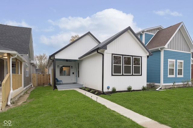 back of property with a lawn and a porch