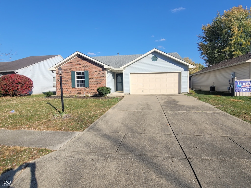 single story home featuring a front lawn and a garage