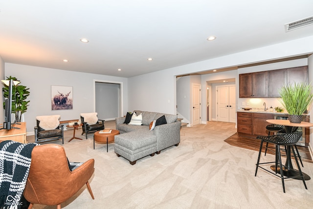 living room featuring light colored carpet and sink