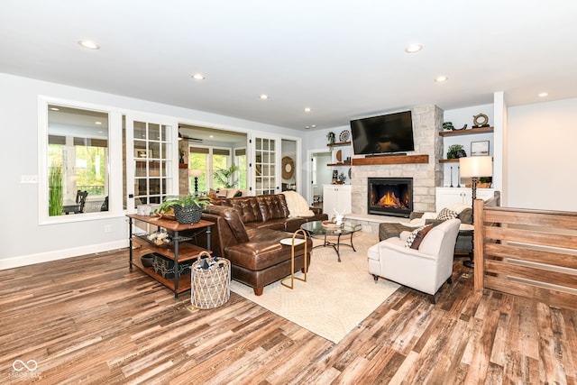 living room with a fireplace, french doors, wood-type flooring, and plenty of natural light