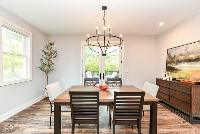 dining space with wood-type flooring and an inviting chandelier