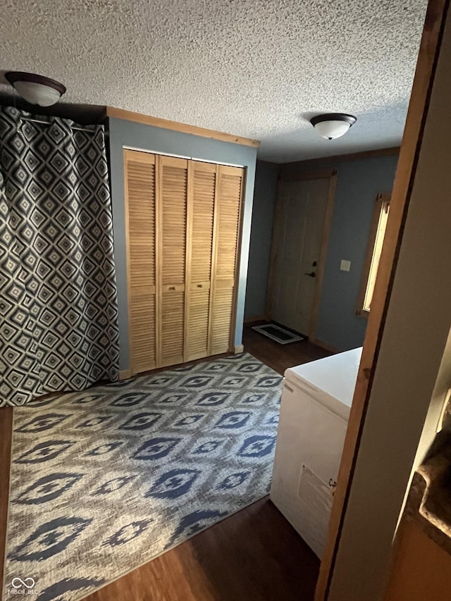 hall featuring hardwood / wood-style flooring and a textured ceiling