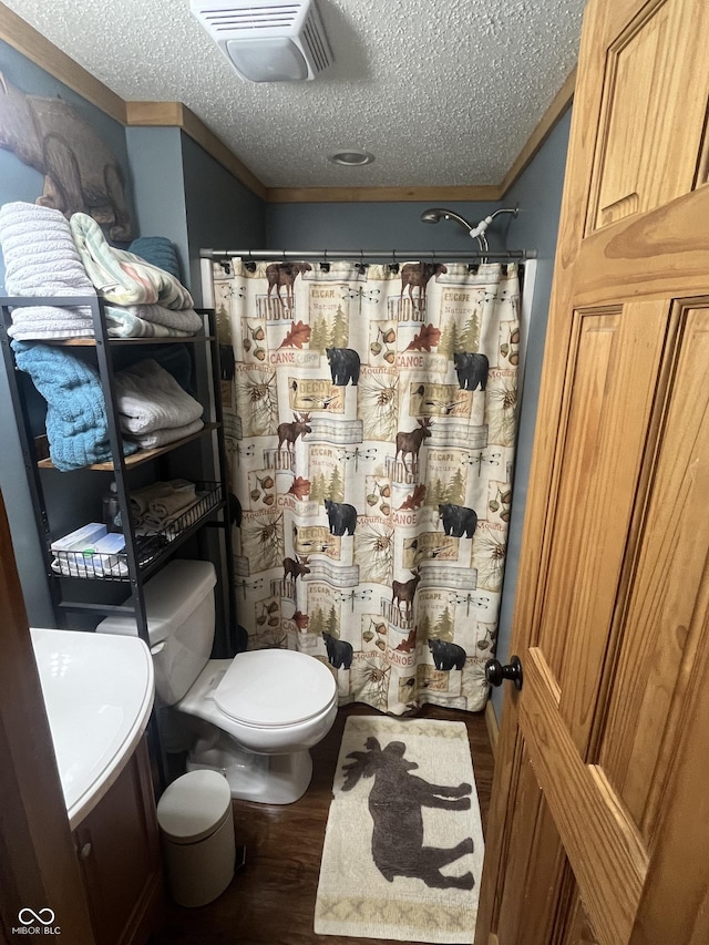 bathroom featuring toilet, a textured ceiling, and hardwood / wood-style flooring