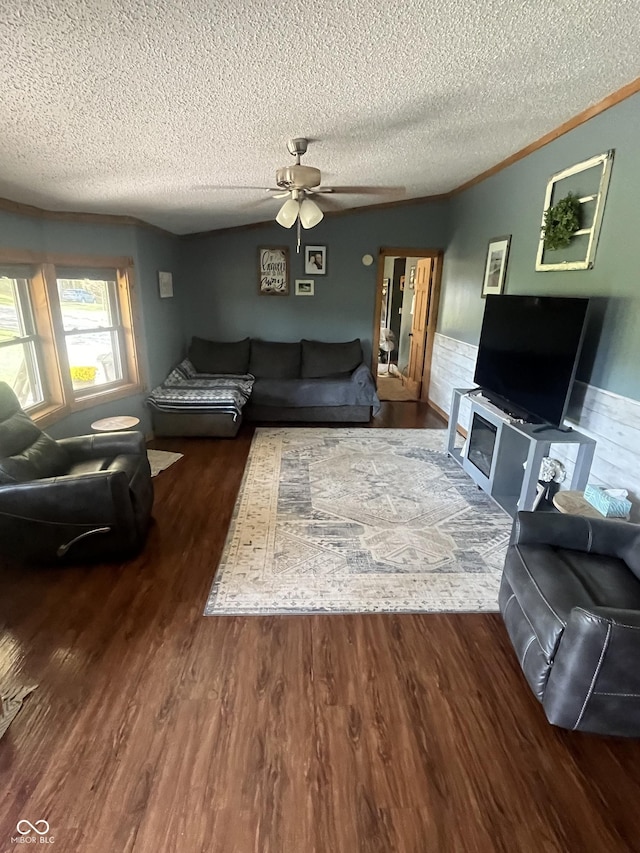 living room featuring a textured ceiling, hardwood / wood-style flooring, ceiling fan, and crown molding